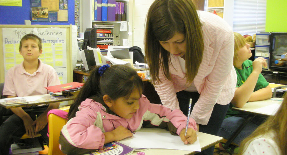 Teacher helping student in classroom